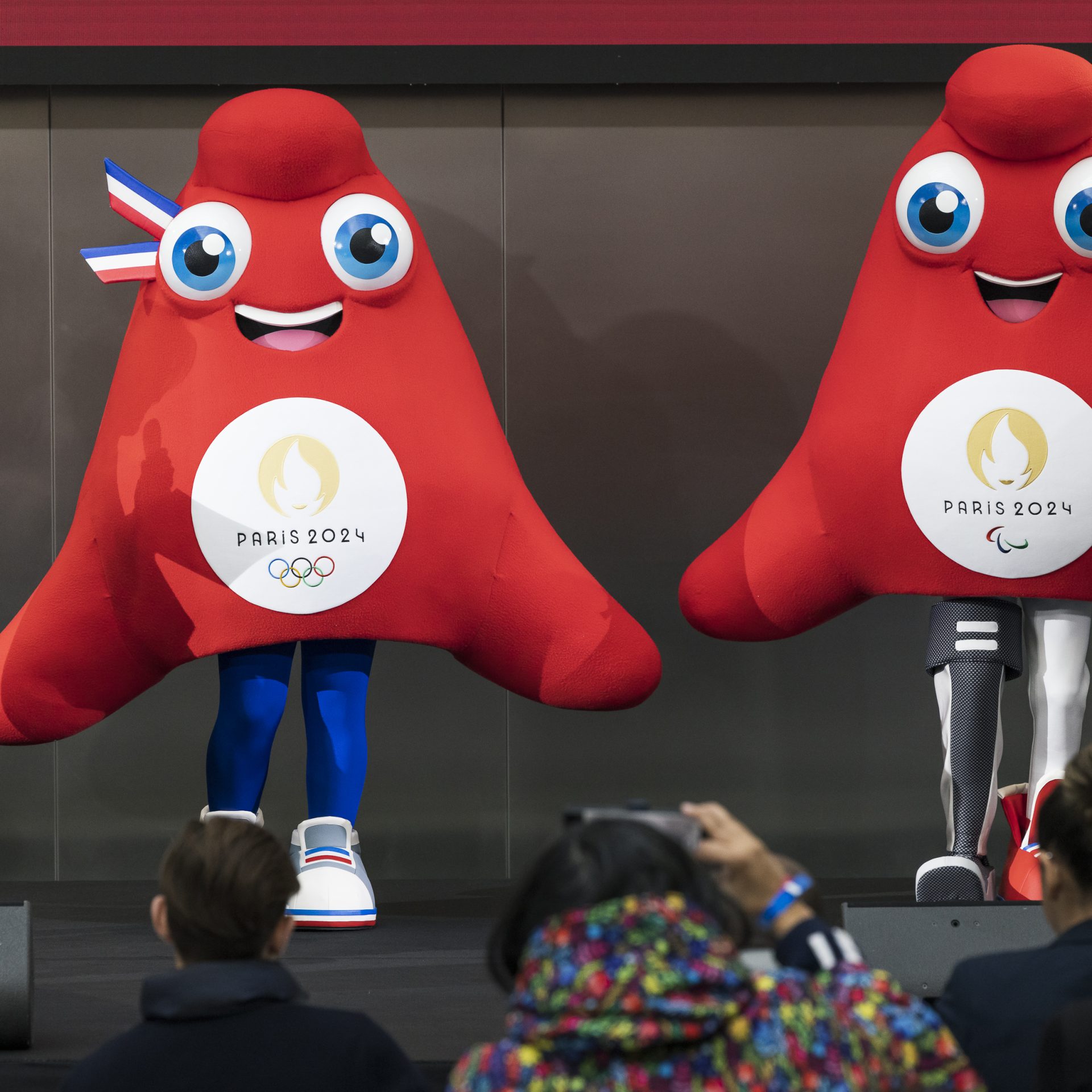 2 בובות בצורת משולש אדום עם ידיים ורגליים, לאחת הבובות פרוטזה במקום רגל